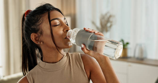 Young woman drinking water during recovery after medical care